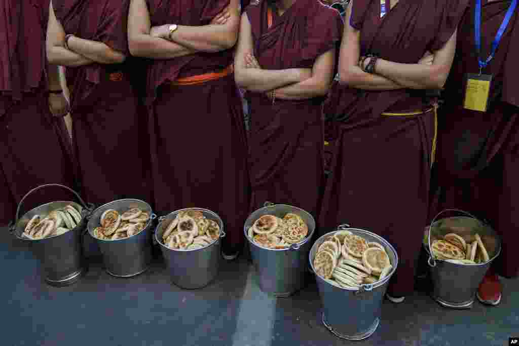 Exiled Tibetan Buddhist nuns wait to distribute bread to a congregation that gathered to listen to Tibetan spiritual leader the Dalai Lama at the Tsuglakhang temple in Dharmsala, India.