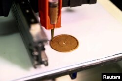 Printer 3D membentuk objek datar menggunakan tinta kayu yang dikembangkan oleh ilmuwan Israel dari Hebrew University of Jerusalem, di Yerusalem, 6 September 2022. Kayu pipih memiliki kemampuan untuk mengeras setelah dikeringkan, dan melengkung menjadi objek 3D. (REUTERS/Ronen Zvulun)