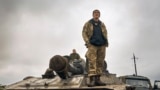 A Ukrainian soldier stands on a tank on the road in the freed territory of the Kharkiv region, Ukraine, Sept. 12, 2022. 