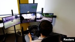 An operator controls a Fetch driverless car from the office of Imperium Drive, during driverless car trials, in Milton Keynes, Britain, June 8, 2022. (REUTERS/Andrew Boyers)