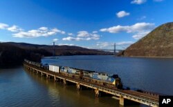 FILE - A CSX Transportation locomotive pulls a train of tank cars across a bridge on the Hudson River along the edge of Bear Mountain State Park near Fort Montgomery, N.Y., on April 26, 2018.
