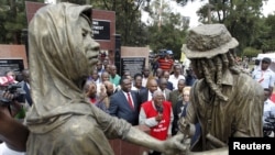 FILE - Gitu wa Kahengeri, center, secretary-general of the Mau Mau War Veterans Association, addresses members during the dedication in Nairobi of a memorial to victims of torture and ill treatment by British colonialists, Sept. 12, 2015.