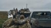 12일 하르키우 수복지에서 진군하는 우크라이나군 병사가 부상당한 전우를 부축하고 있다. 