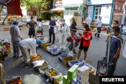 2022年9月5日，中国新疆维吾尔自治区乌鲁木齐市天山区的居民在水果摊位前排队购物