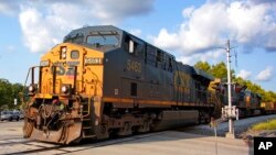 A CSX freight train runs through a crossing in Homestead, Pa., Sept. 14, 2022.