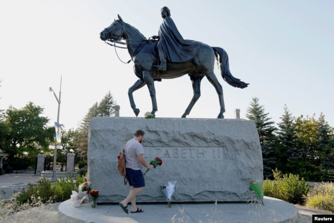 FILE PHOTO: Breton Cousins brings flowers to a statue of Queen Elizabeth II near Rideau Hall, after Queen Elizabeth, Britain's longest-reigning monarch and the nation's figurehead for seven decades, died aged 96, in Ottawa, Ontario, Canada, September 8,