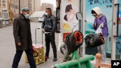 戴著口罩的民眾在新疆街頭。新疆伊犁自治州伊寧縣的民眾表示，在因為新冠病毒而封控40多天后，他們正在經歷飢餓和強迫隔離 (資料圖片)