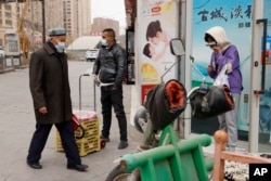 戴着口罩的民众在新疆街头。新疆伊犁自治州伊宁县的民众表示，在因为新冠病毒而封控40多天后，他们正在经历饥饿和强迫隔离(资料图片)