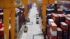 FILE - A truck driver stands next to his truck as he gets ready to transport a shipping container at Pusan Newport Terminal in Busan, South Korea, July 1, 2021. 