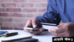 মোবাইলে কেনাকাটা করছেন এক ব্যক্তি 