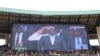 Crowds are seen under a screen showing Kenya's President William Ruto, during his swearing-in ceremony at Moi International Stadium Kasarani in Nairobi, Sept. 13, 2022. 