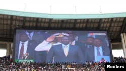 Crowds are seen under a screen showing Kenya's President William Ruto, during his swearing-in ceremony at Moi International Stadium Kasarani in Nairobi, Sept. 13, 2022. 