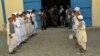 Afghan children hold flags as they stand outside their school to mark the beginning of new academic year in Kandahar, Sept. 7, 2022.