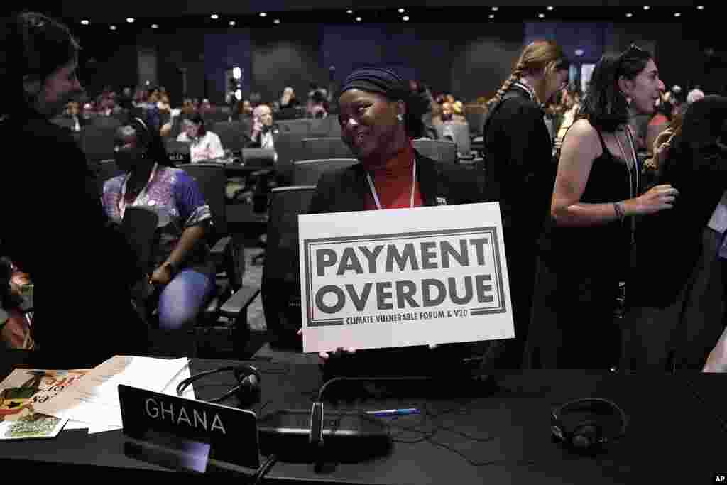 Nakeeyat Dramani Sam, of Ghana, holds a sign that reads &quot;payment overdue&quot; at the COP27 U.N. Climate Summit, in Sharm el-Sheikh, Egypt. She made a plea for negotiators at the summit to come to an agreement that could help slow global warming.