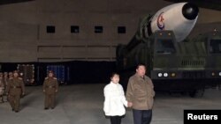 2022年11月19日，北韓領導人金正恩手牽著他女兒金主愛（Kim Ju Ae)的手視察一枚北韓製造的洲際彈道導彈。該照片由朝中社發布，路透社提供。
