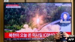 FILE - A man watches a television showing a news broadcast with file footage of a North Korean missile test, at a railway station in Seoul on Nov. 18, 2022. 