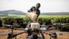 Un employé de Sasini met de l'engrais à l'intérieur d'un véhicule aérien sans pilote (UAV) au Kipkebe Tea Estate (Kenya).