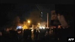 This image grab from UGC video footage made available on the ESN platform through Hengaw Organisation for Human Rights on Nov. 16, 2022, reportedly shows Iranian protesters surrounding the municipality building in the western Kurdish-majority city of Buk