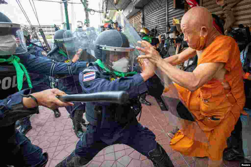 A protester clashes with riot police officers during a protest against the Asia-Pacific Economic Cooperation (APEC) Summit 2022, near the Democracy Monument in Bangkok, Thailand.