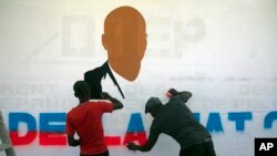 Artistas pintan un retrato del finado presidente haitiano Jovenel Moise cerca de la residencia presidencial donde fue asesinado en el área de Petion-ville de Puerto Príncipe, Haití, el jueves 7 de julio de 2022.