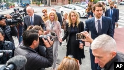 Theranos founder and CEO Elizabeth Holmes, center, walks into federal court with her partner, Billy Evans, right, and her parents in San Jose, Calif., Nov. 18, 2022. A federal judge sentenced her to prison for duping investors and endangering patients whi