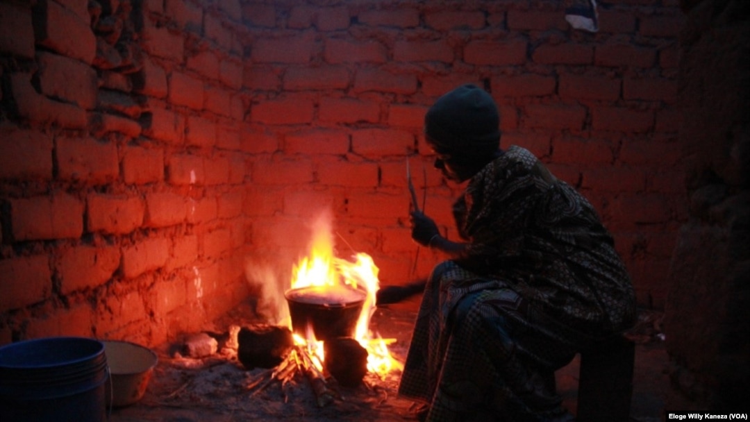 Umwe mu bakenyezi bo mu Burundi yenyegeza inkono yiwe