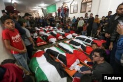 Warga Palestina menghadiri pemakaman 21 orang yang tewas dalam kebakaran yang terjadi saat pesta di Jalur Gaza, 18 November 2022. (REUTERS/Ibraheem Abu Mustafa)