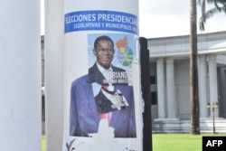 FILE - A campaign poster for Equatorial Guinea President Teodoro Obiang Nguema is pasted over a campaign poster of opponent Essono Ondo Andress, in Malabo, Nov. 17, 2022.