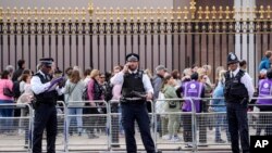 Police officers stand outside Buckingham Palace in London, Sept. 18, 2022.