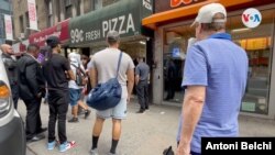 Varias personas esperan en fila frente a un puesto de pizzas en Manhattan, Nueva York. Foto: Antoni Belchi / VOA