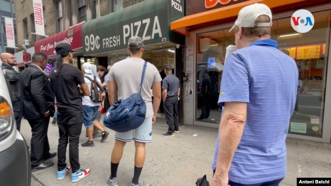 Varias personas esperan en fila frente a un puesto de pizzas en Manhattan, Nueva York. Foto: Antoni Belchi / VOA