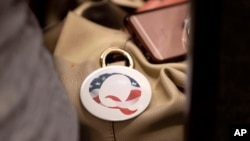 FILE - A QAnon conspiracy theory button sits affixed to the purse of an attendee of the Nebraska Election Integrity Forum on Aug. 27, 2022, in Omaha, Neb.