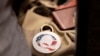 Pin QAnon, sebuah teori konspirasi, terpasang pada salah satu tas milik pengunjung acara Forum Integritas Pemilu Nebraska yang digelar di Omaha, Nebraska, pada 27 Agustus 2022. (Foto: AP/Rebecca S. Gratz)