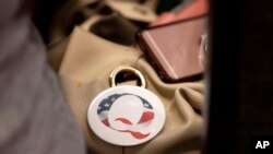 Pin QAnon, sebuah teori konspirasi, terpasang pada salah satu tas milik pengunjung acara Forum Integritas Pemilu Nebraska yang digelar di Omaha, Nebraska, pada 27 Agustus 2022. (Foto: AP/Rebecca S. Gratz)