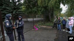 俄罗斯9月26日发生两起枪击案，其中一起发生在俄罗斯中西部乌德穆尔特共和国首府伊热夫斯克第88学校，图为枪击案现场有人献花，有人驻足表示哀悼。第88学校的枪击案造成13人死亡，其中有7名儿童，另外还有21人受伤。-美联社照片