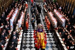 Britain's King Charles III, left, Camilla, Queen Consort, Princess Anne, Vice Admiral Timothy Laurence, Prince Andrew, Prince Edward, Sophie, Countess of Wessex, Prince William, Prince George Catherine, Princess of Wales, Prince Harry and Meghan, Duchess of Sussex walk behind the coffin of Queen Elizabeth II as they leave Westminster Abbey in central London, Monday Sept. 19, 2022. (Ben Stansall/Pool via AP)