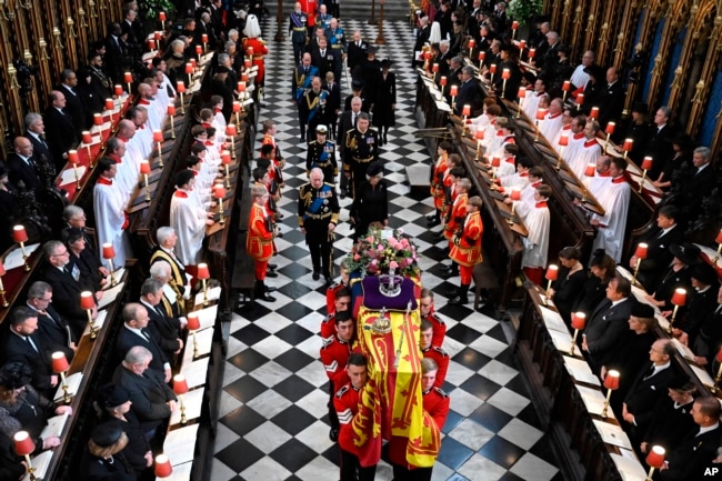 Britain's King Charles III, left, Camilla, Queen Consort, Princess Anne, Vice Admiral Timothy Laurence, Prince Andrew, Prince Edward, Sophie, Countess of Wessex, Prince William, Prince George Catherine, Princess of Wales, Prince Harry and Meghan, Duchess of Sussex walk behind the coffin of Queen Elizabeth II as they leave Westminster Abbey in central London, Monday Sept. 19, 2022. (Ben Stansall/Pool via AP)
