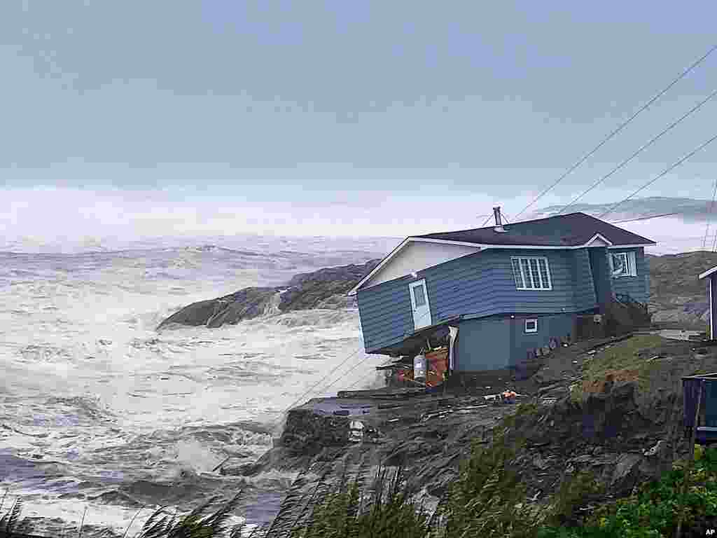 In this photo provided by Wreckhouse Press, a home is hit with high winds caused by post Tropical Storm Fiona in Port aux Basques, Newfoundland and Labrador, Sept. 24, 2022. The home has since been lost at sea. 
