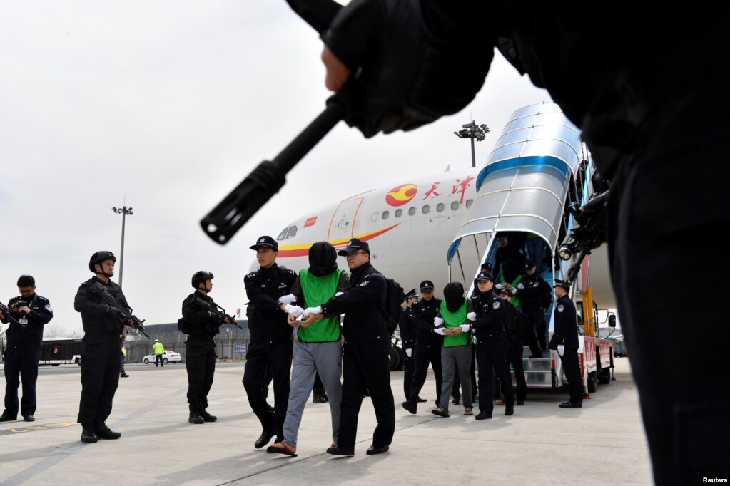 中国警察在天津机场押送一批从菲律宾遣返的台湾籍电信诈骗嫌疑人。（2018年4月4日）(photo:VOA)