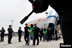 中国警察在天津机场押送一批从菲律宾遣返的台湾籍电信诈骗嫌疑人。（2018年4月4日）