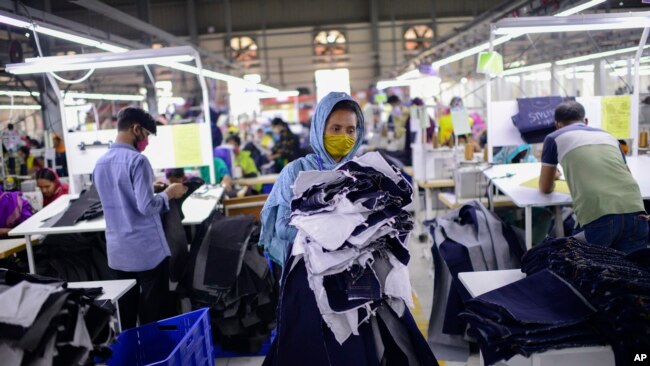 FILE - Garment factory employees work at Arrival Fashion Ltd. in Gazipur, Bangladesh, March 13, 2021.