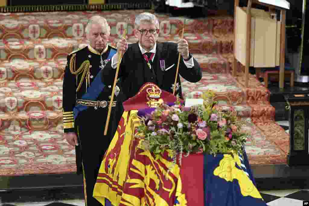 King Charles II, left, watches as The Lord Chamberlain Baron Parker breaks his Wand of Office, marking the end of his service to the sovereign, during the Committal Service for Queen Elizabeth at St. George&#39;s Chapel, Windsor Castle in Windsor, Sept. 19, 2022.