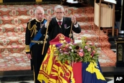 Raja Charles II, kiri, menyaksikan Lord Chamberlain Baron Parker mematahkan tongkatnya, menandai akhir pengabdiannya kepada Ratu Elizabeth, di Kapel St. George, Kastil Windsor. (Foto: via AP)