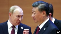 FILE - Russian President Vladimir Putin, left, gestures while speaking to Chinese President Xi Jinping during the Shanghai Cooperation Organization summit in Samarkand, Uzbekistan, Sept. 16, 2022.