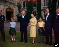 FILE - Britain's Queen Elizabeth II stands on the grounds of Balmoral Castle, in Royal Deeside, Scotland, between U.S. President Dwight D. Eisenhower and Prince Charles, Aug. 29, 1959.