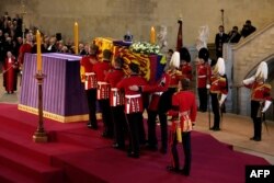 Pembawa jenazah dari The Queen's Company, Pengawal Grenadier Batalyon 1 membawa peti mati Ratu Elizabeth II ke Westminster Hall di Istana Westminster di London pada 14 September 2022. (Foto: AFP)
