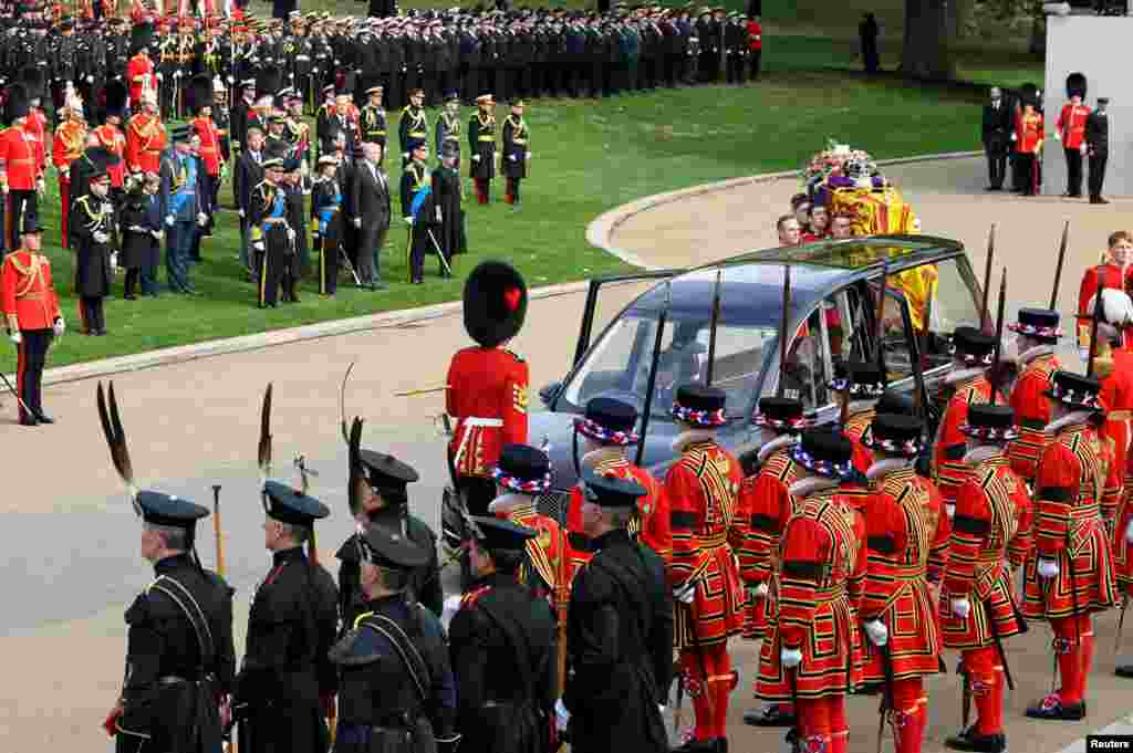 Members of the British royal family and members of the military stand as the coffin of Queen Elizabeth is carried to a hearse to be taken from Wellington Arch in London to Windsor Castle on the day of her state funeral and burial, Sept. 19, 2022.