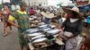 NIGERIA - INFLATION/ economy - women buy food at a market - woman sells fish - economy business