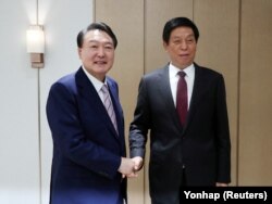 韩国总统尹锡悦（左）在首尔龙山总统府会见到访的中国全国人大常委会委员长栗战书。（2022年9月16日）