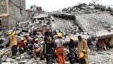 Rescuers take a break at the scene of a collapsed building, blamed on poor construction materials in Kirigiti, Kiambu county, on September 26, 2022.